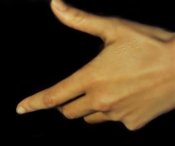 Implante braille en las manos para dar información al saludar