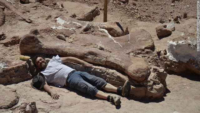 Uno de los paleontólogos posando con el fémur del Titanousario
